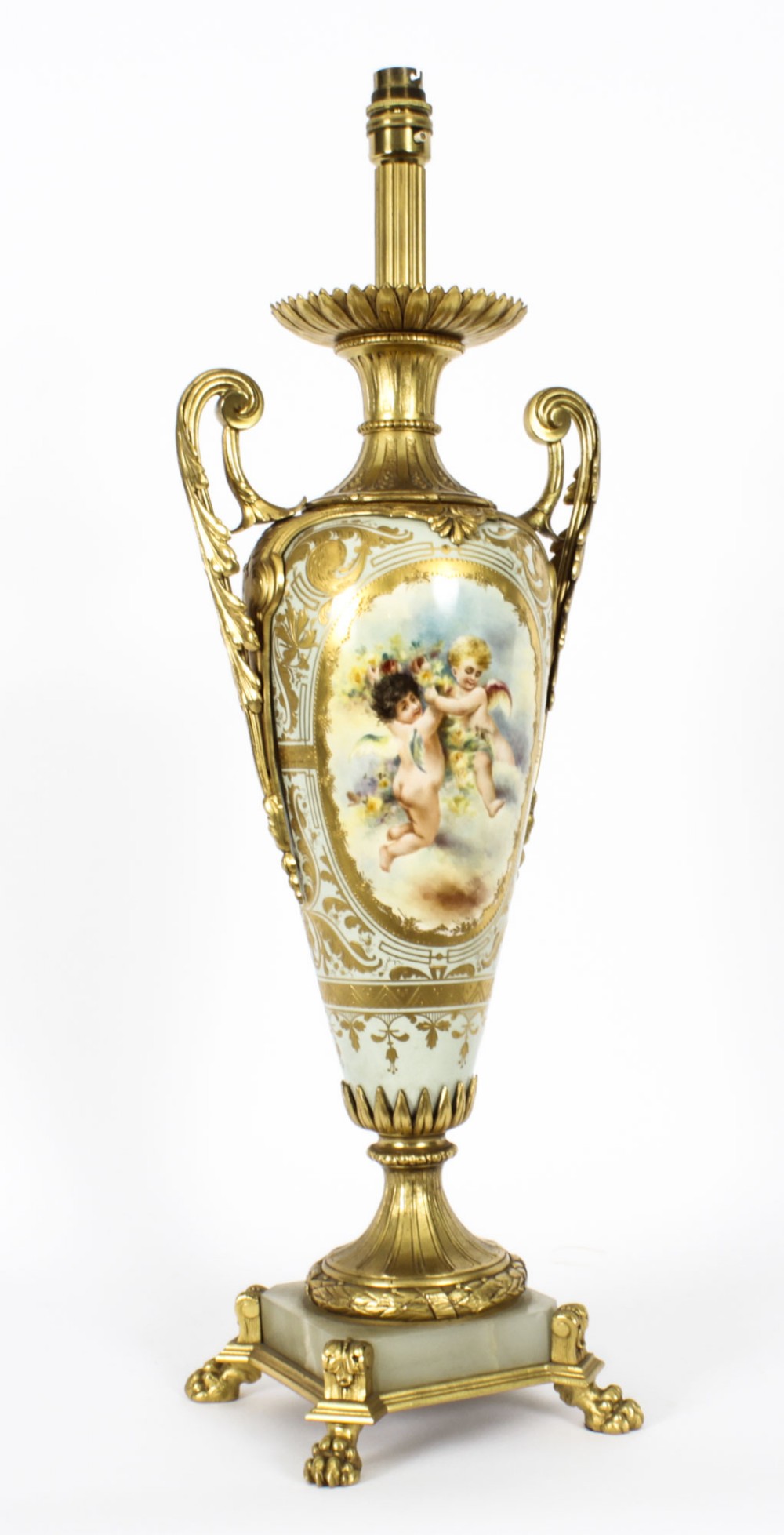A 19th-century French Sevres-style porcelain urn lamp painted with cherubs, featuring gilt bronze handles, foliage mounts, and an onyx base.
