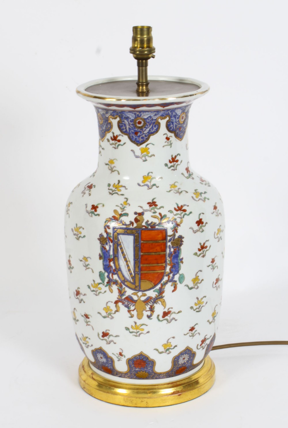 A 19th-century French Samson porcelain table lamp featuring a hand-painted heraldic crest, floral sprigs, and gilt mounts.