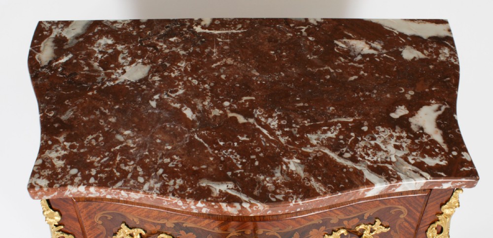 A 19th-century French Louis XV Revival commode with floral marquetry inlay, a variegated marble top, three drawers, and gilt-bronze mounts. View III