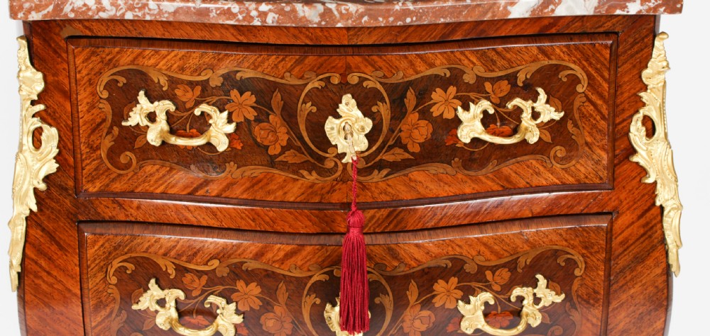 A 19th-century French Louis XV Revival commode with floral marquetry inlay, a variegated marble top, three drawers, and gilt-bronze mounts. View VII