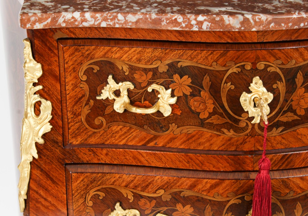 A 19th-century French Louis XV Revival commode with floral marquetry inlay, a variegated marble top, three drawers, and gilt-bronze mounts. View VIII