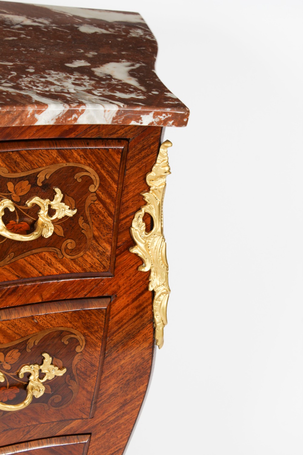 A 19th-century French Louis XV Revival commode with floral marquetry inlay, a variegated marble top, three drawers, and gilt-bronze mounts. View XI