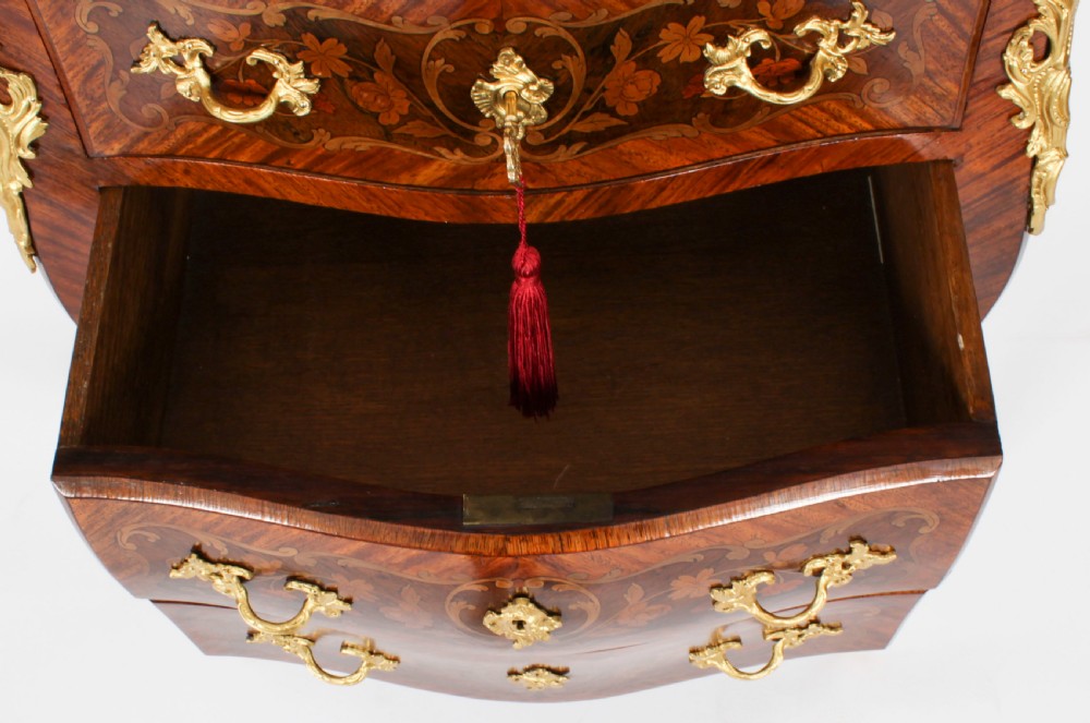 A 19th-century French Louis XV Revival commode with floral marquetry inlay, a variegated marble top, three drawers, and gilt-bronze mounts. View XV