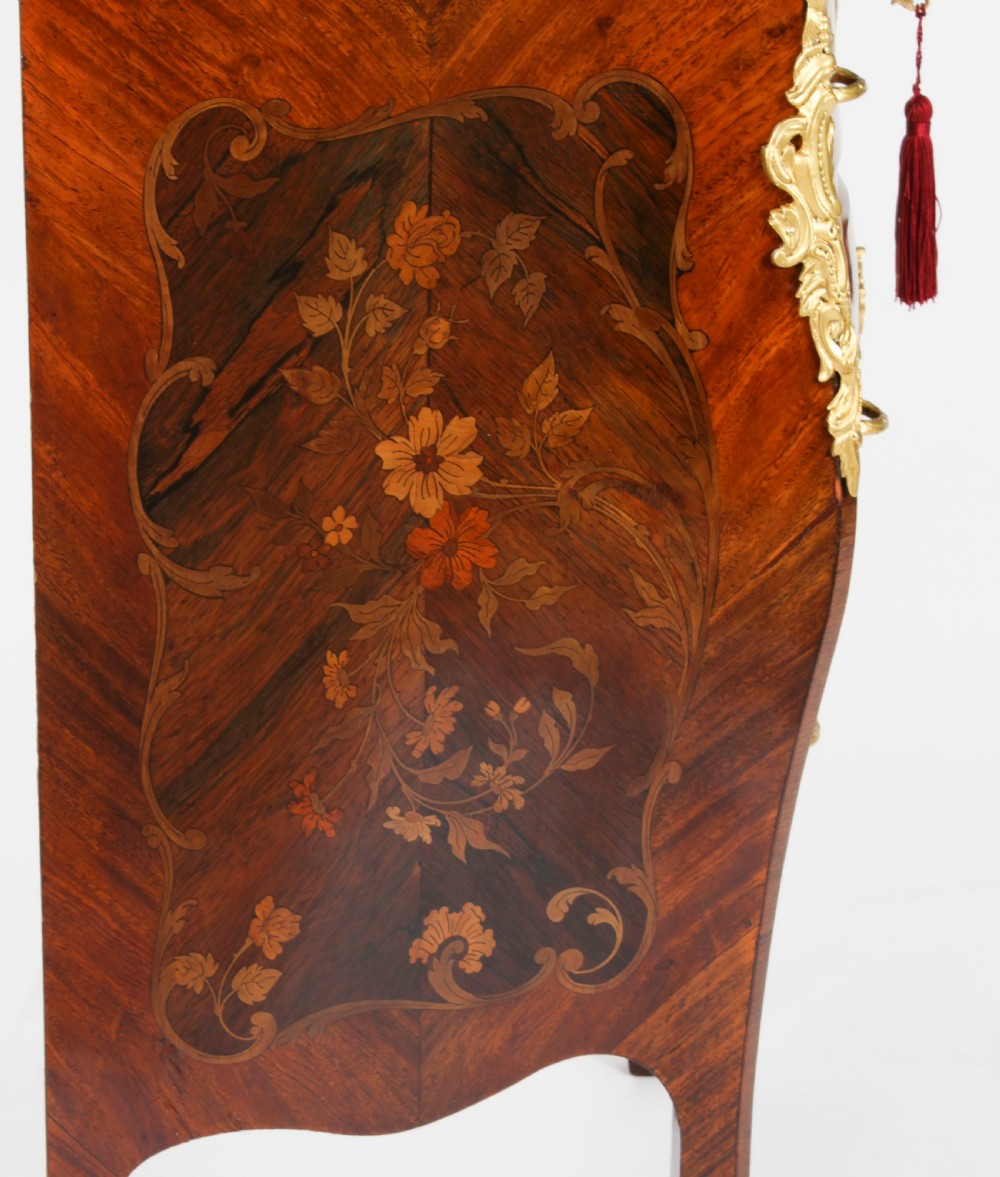 A 19th-century French Louis XV Revival commode with floral marquetry inlay, a variegated marble top, three drawers, and gilt-bronze mounts. View XX