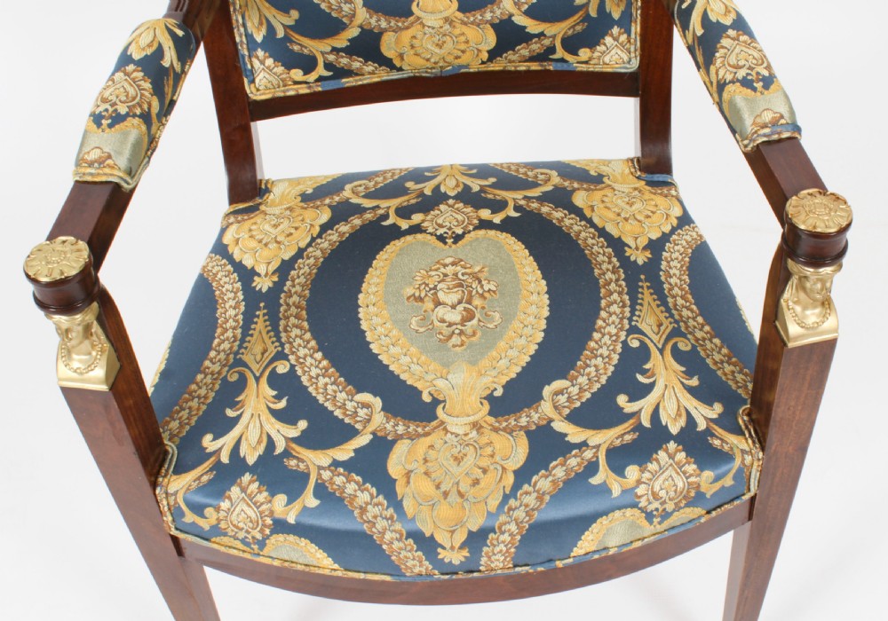 A pair of 19th-century French Empire Revival mahogany armchairs upholstered in blue and gold patterned silk damask featuring gilt ormolu mounts. View V