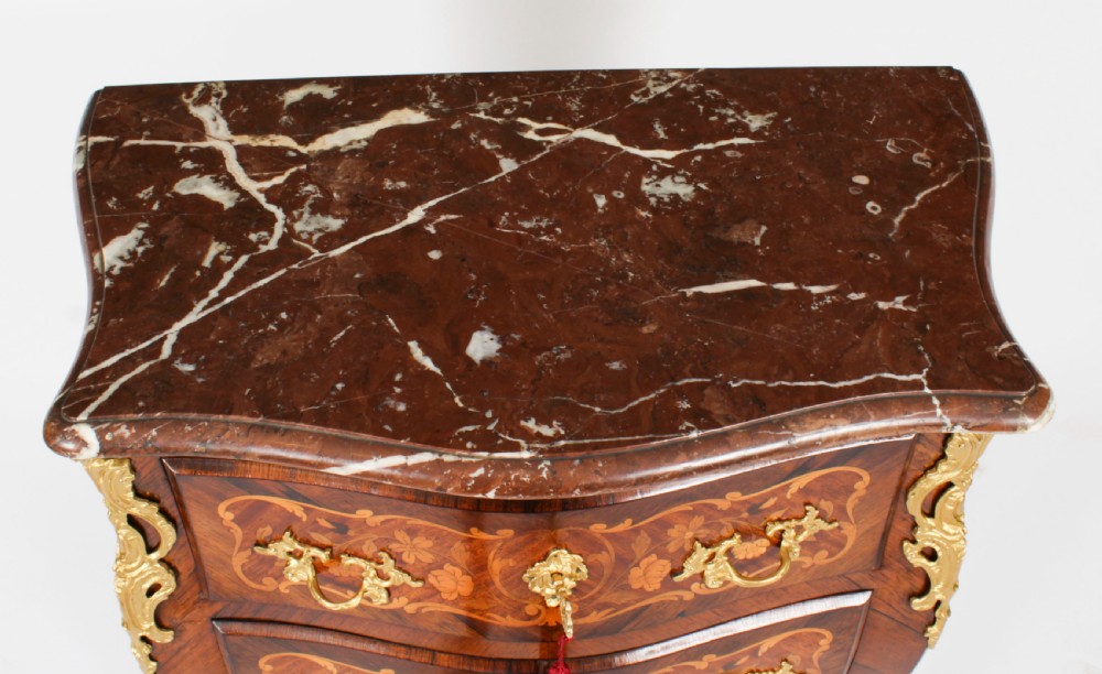 A French Louis XV Revival style marquetry commode featuring floral timber inlays, gilt-bronze mounts, three drawers, and a contoured marble top. View III