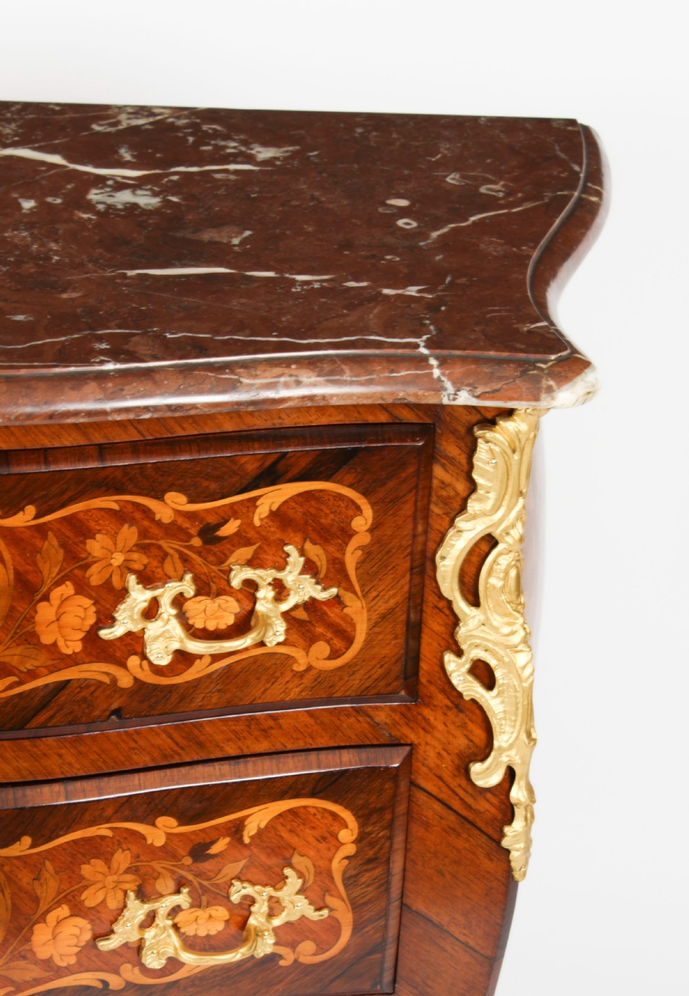 A French Louis XV Revival style marquetry commode featuring floral timber inlays, gilt-bronze mounts, three drawers, and a contoured marble top. View VII