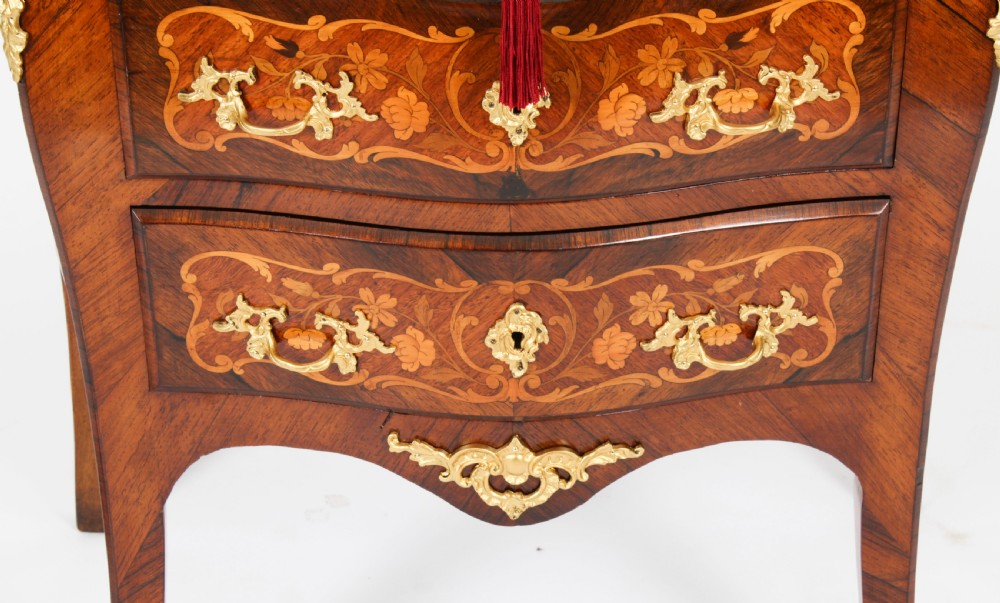 A French Louis XV Revival style marquetry commode featuring floral timber inlays, gilt-bronze mounts, three drawers, and a contoured marble top. View IX