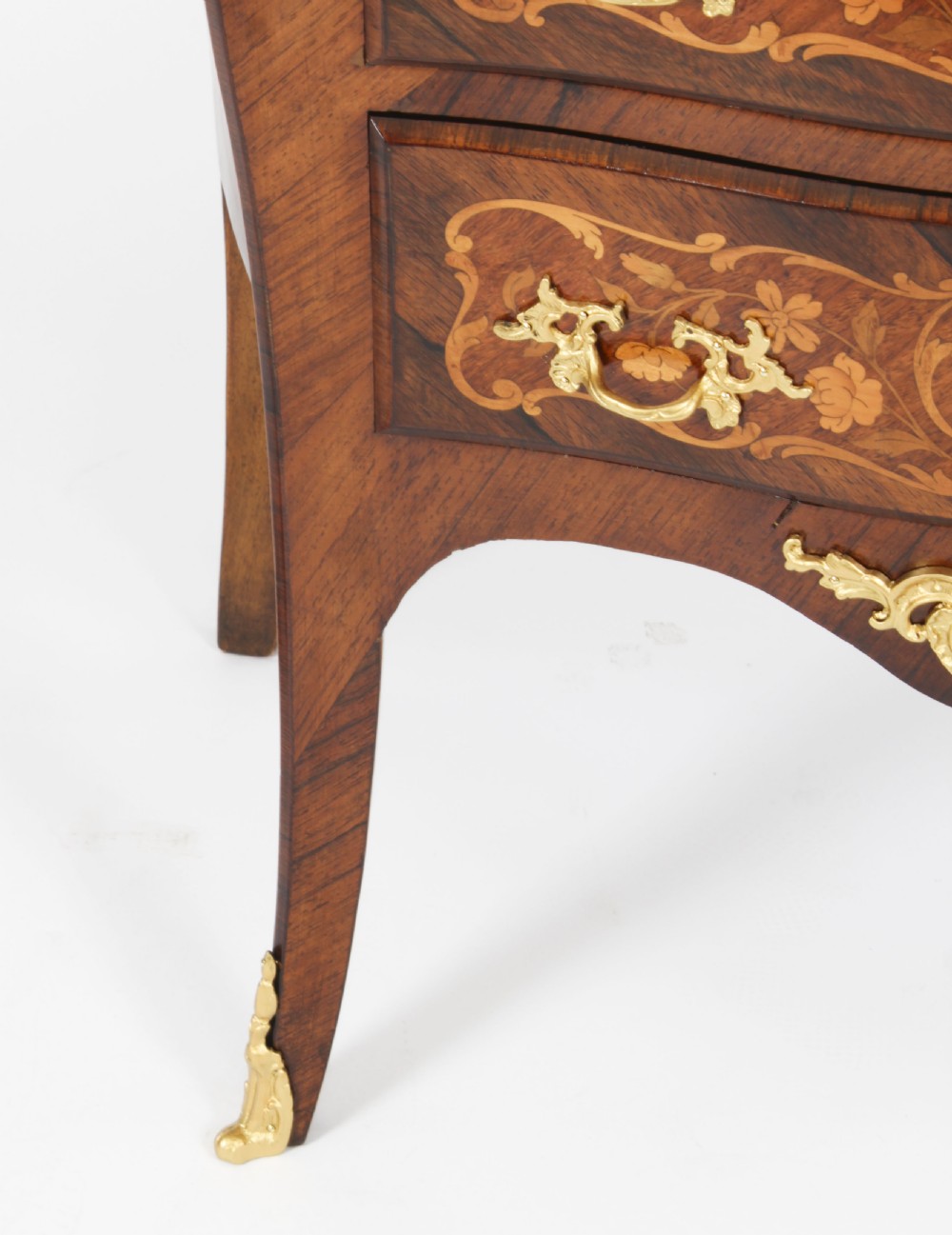 A French Louis XV Revival style marquetry commode featuring floral timber inlays, gilt-bronze mounts, three drawers, and a contoured marble top. View X