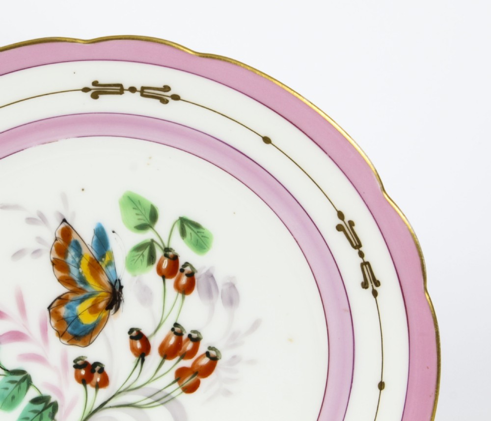 An antique French porcelain cabinet plate featuring a scalloped pink border with gilded accents and a central hand-painted motif of a butterfly and wild berries. View III