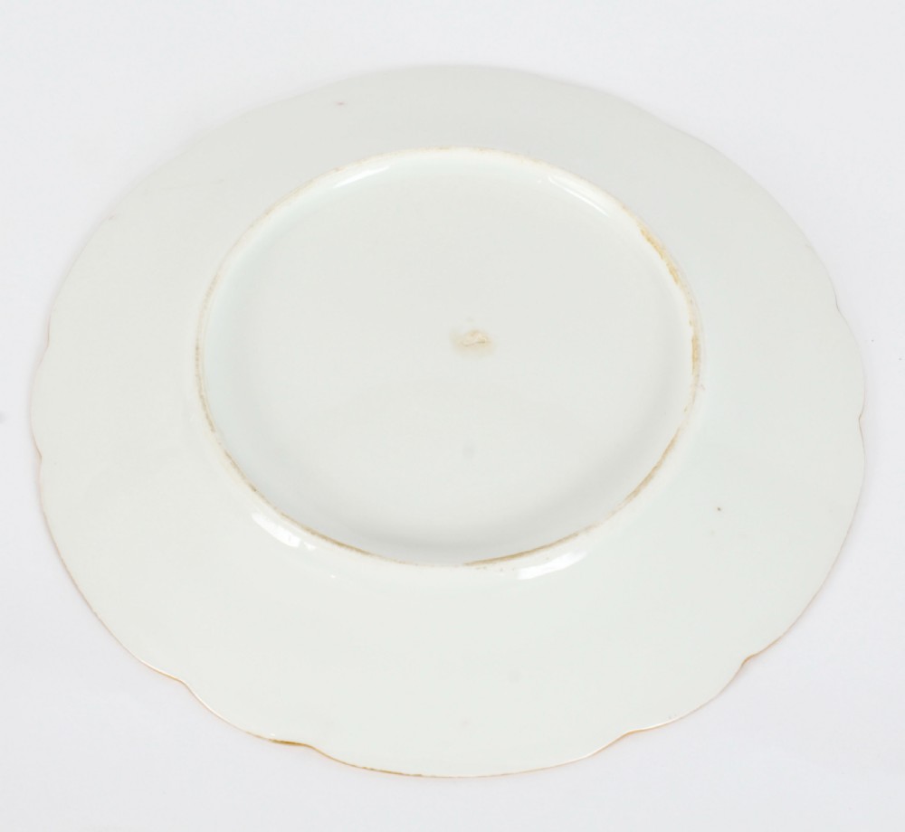 An antique French porcelain cabinet plate featuring a scalloped pink border with gilded accents and a central hand-painted motif of a butterfly and wild berries. View IV