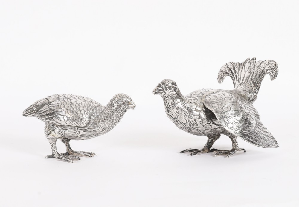 A pair of 19th-century silver game bird figurines depicting grouse with detailed chased feather texturing.