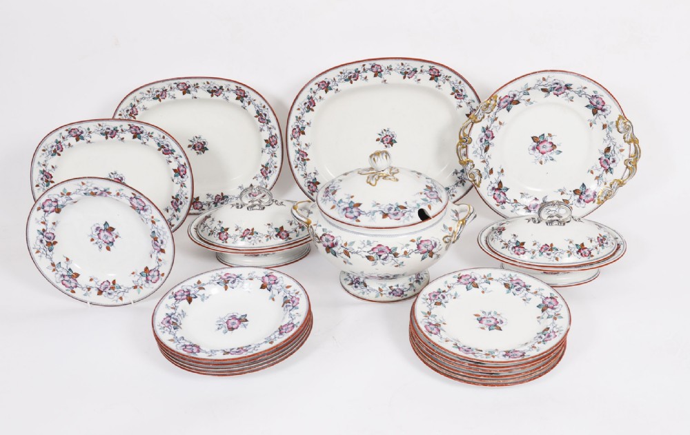 A twenty-two piece antique Muller Volkstedt porcelain dinner service featuring white ground with floral borders, red rims, gold accents, including a large tureen, serving platters, and plates.