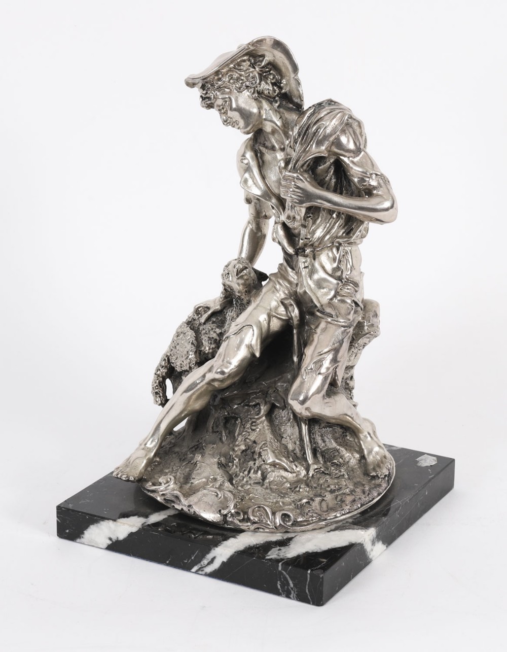 A 19th-century silvered bronze sculpture depicting a young shepherd seated beside a lamb, mounted on a square black veined marble base.