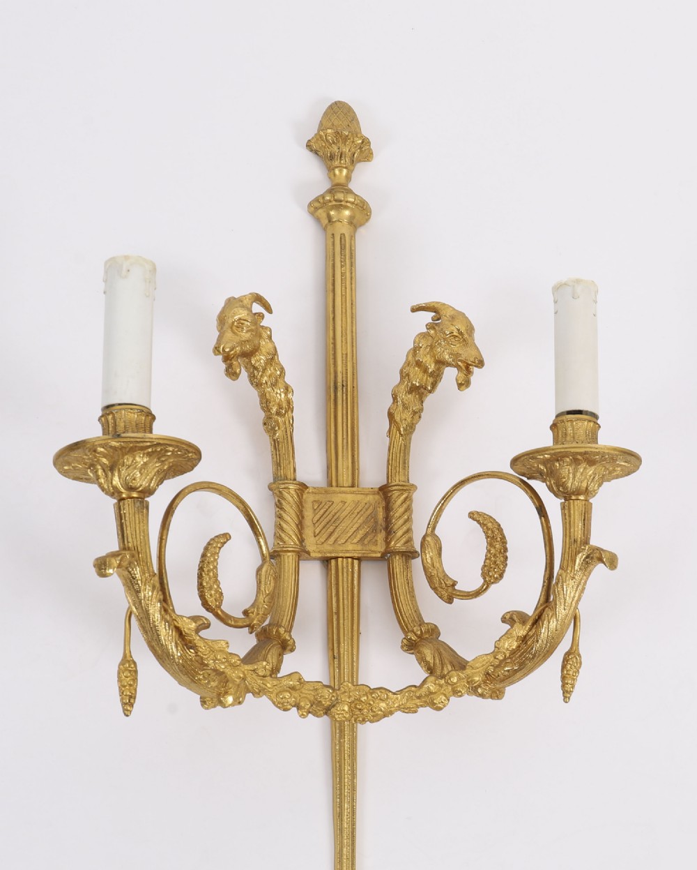 A pair of nineteenth-century French Neoclassical gilt bronze wall lights featuring twin candle arms decorated with goat heads and pinecone finials. View IX