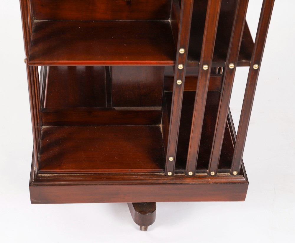 A two-tier dark mahogany revolving bookcase featuring vertical slatted sides with brass stud detailing, resting on a quadform base with castors. View VIII