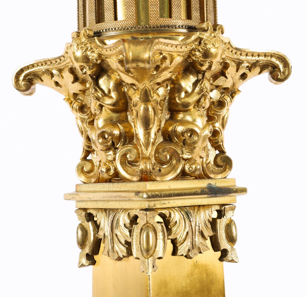 A pair of 19th-century French ormolu table lamps featuring cast gilt bronze bases and cream flared fabric shades with tassel fringe trim. View IX