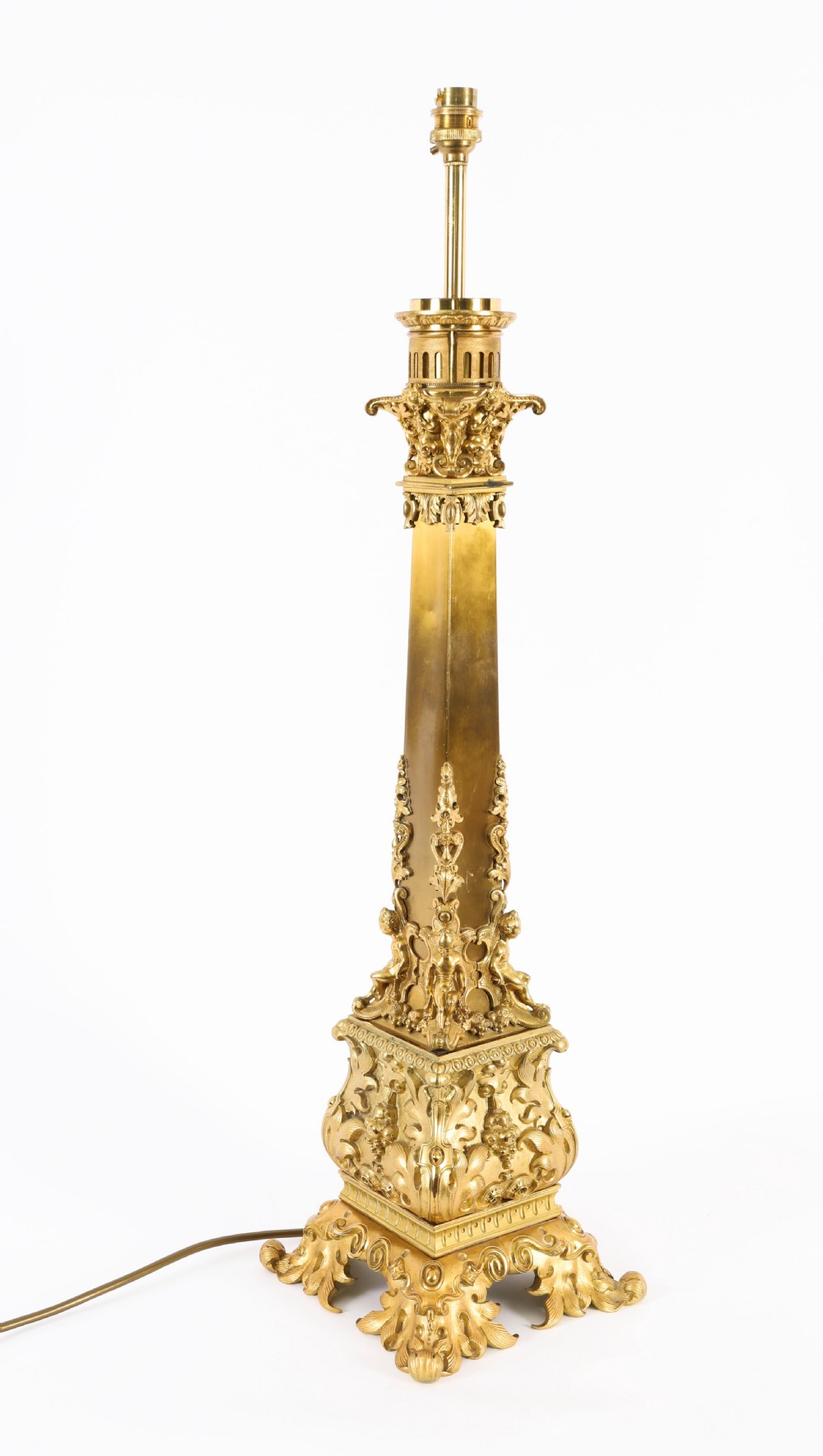A pair of 19th-century French ormolu table lamps featuring cast gilt bronze bases and cream flared fabric shades with tassel fringe trim. View XV