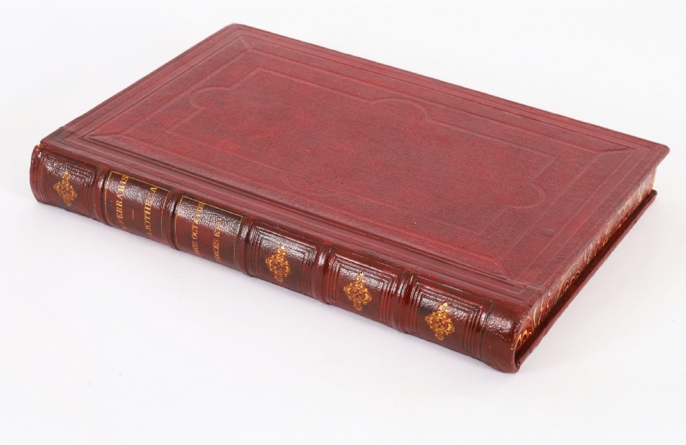 An open red marbled book-form box displaying seven oval cream plaster intaglios behind glass alongside an engraved frontispiece. View III