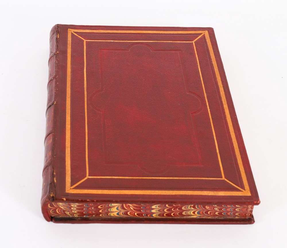 An open red marbled book-form box displaying seven oval cream plaster intaglios behind glass alongside an engraved frontispiece. View VIII