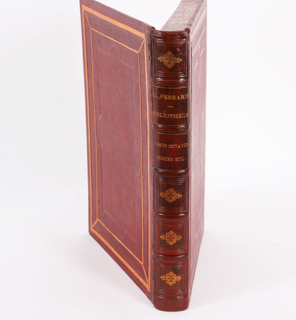 An open red marbled book-form box displaying seven oval cream plaster intaglios behind glass alongside an engraved frontispiece. View IX