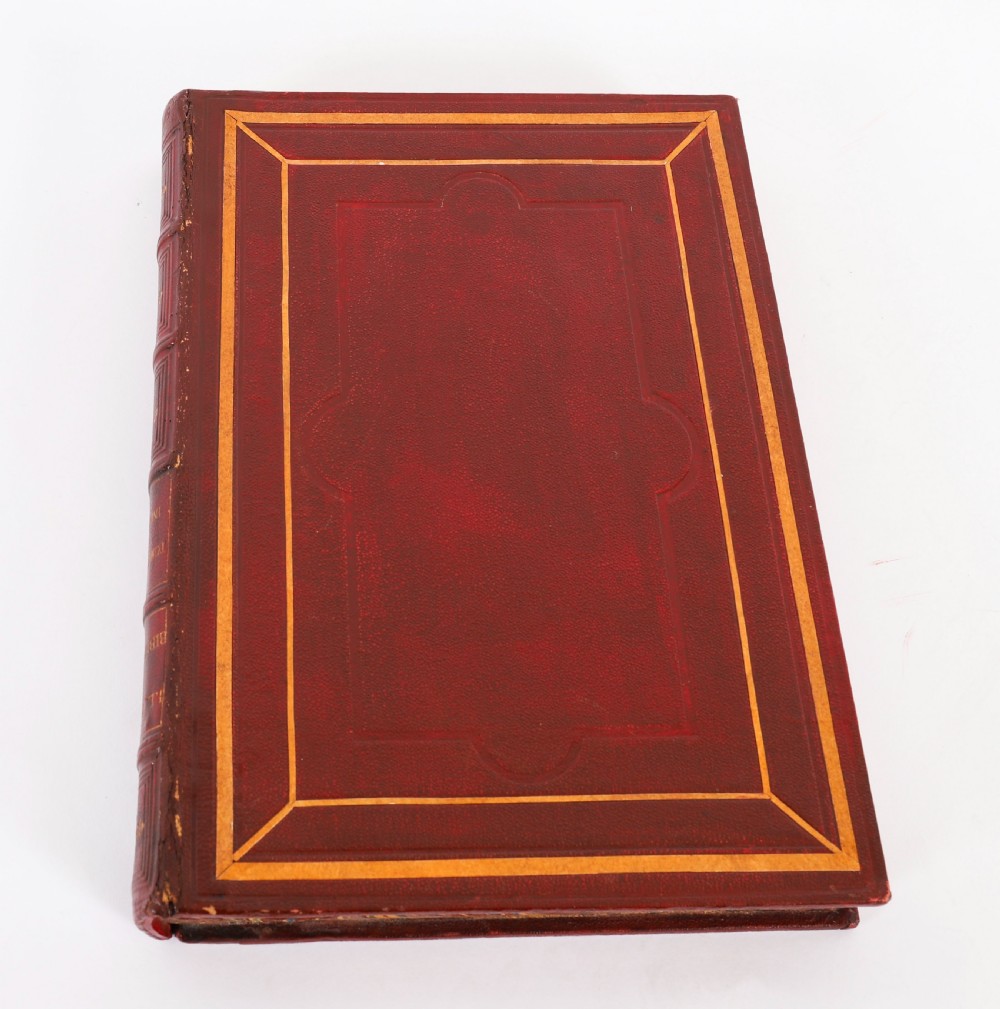 An open red marbled book-form box displaying seven oval cream plaster intaglios behind glass alongside an engraved frontispiece. View XVIII
