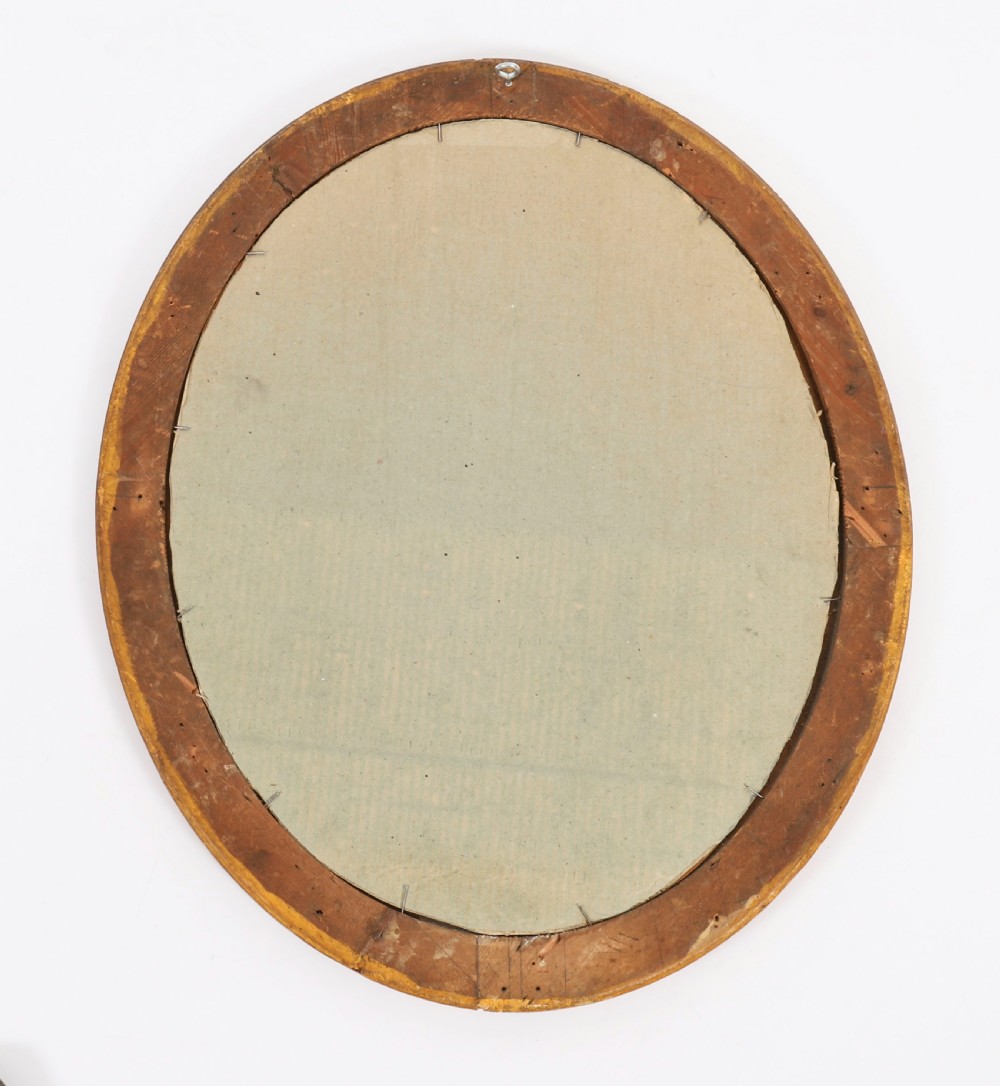 A matching pair of 19th-century French oval wall mirrors featuring carved giltwood frames with a beaded pattern and gold leaf finish. View VII