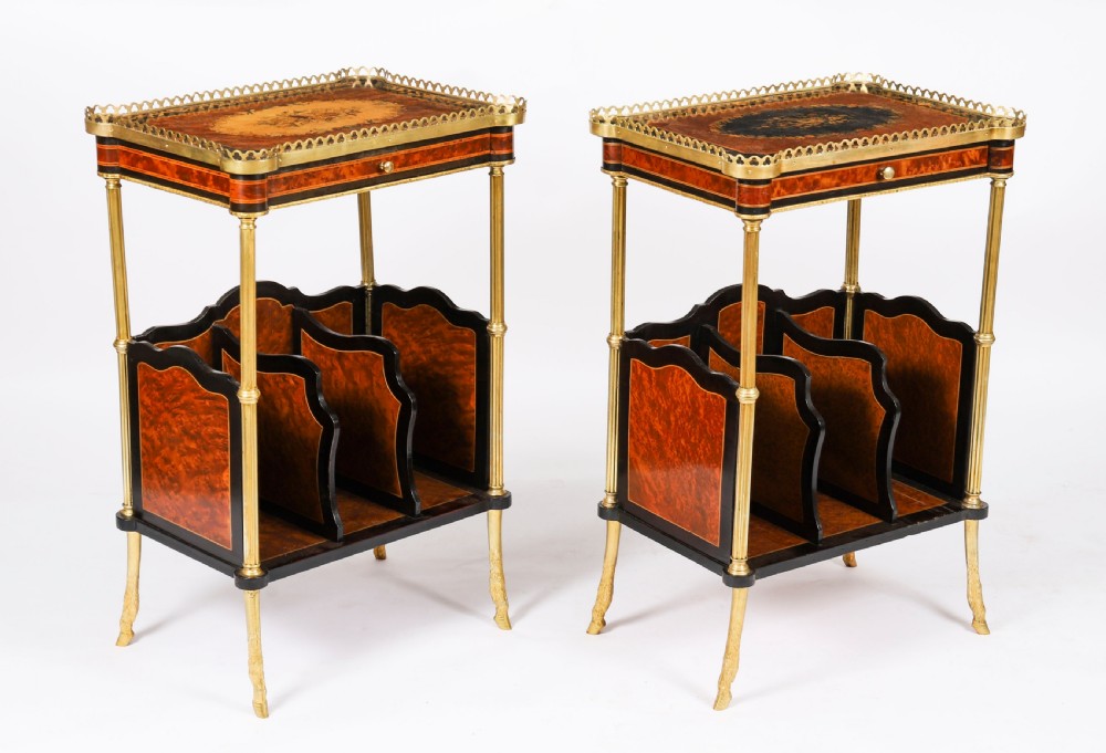 A pair of 19th-century French occasional side tables featuring marquetry tops with brass gallery rails, lower partitioned racks, and gilt metal legs.