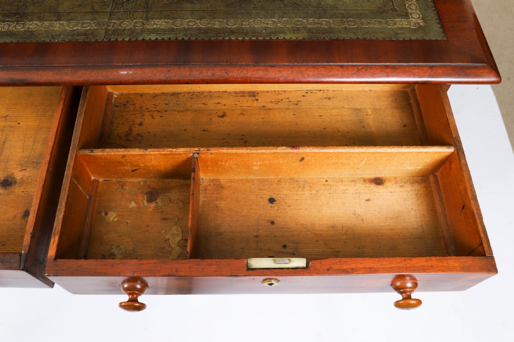 A Victorian flame mahogany partners pedestal desk featuring a green leather inset writing surface and turned wooden knobs. View VII