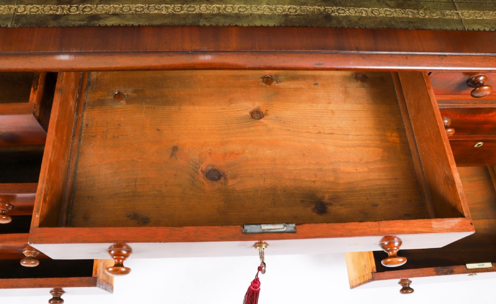 A Victorian flame mahogany partners pedestal desk featuring a green leather inset writing surface and turned wooden knobs. View XIV