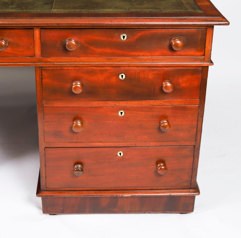 A Victorian flame mahogany partners pedestal desk featuring a green leather inset writing surface and turned wooden knobs. View XV
