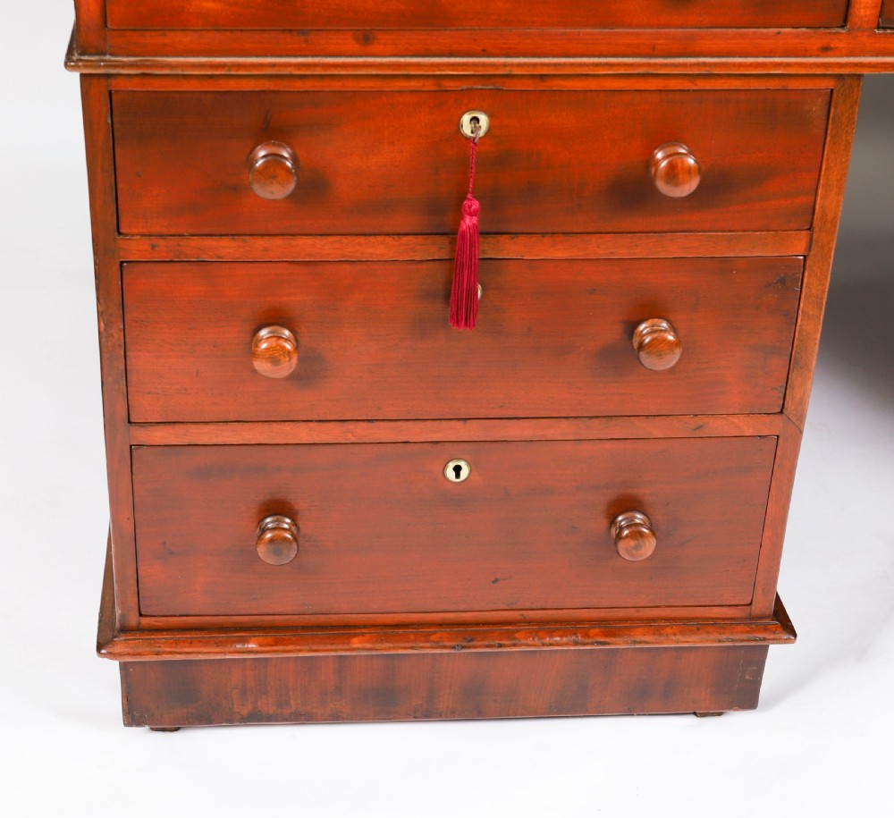 A Victorian flame mahogany partners pedestal desk featuring a green leather inset writing surface and turned wooden knobs. View XVI
