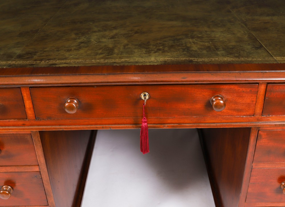 A Victorian flame mahogany partners pedestal desk featuring a green leather inset writing surface and turned wooden knobs. View XVIII