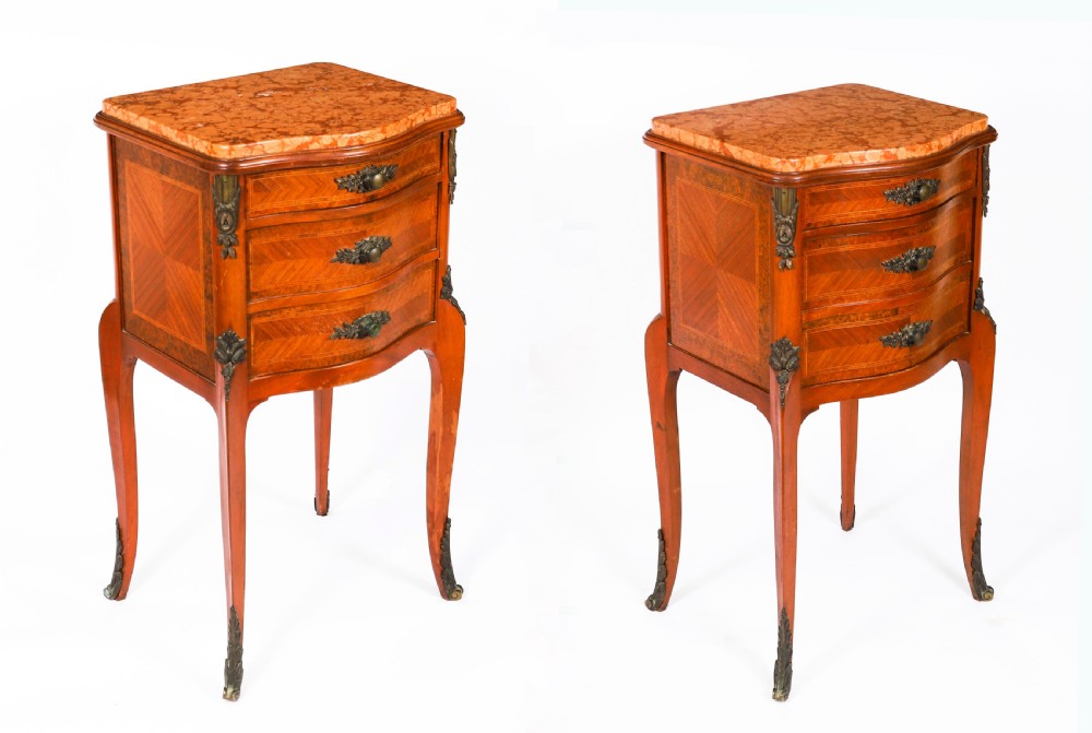 A pair of 19th-century French Louis XV style parquetry bedside cabinets featuring marble tops, three drawers, and cabriole legs with bronze mounts.