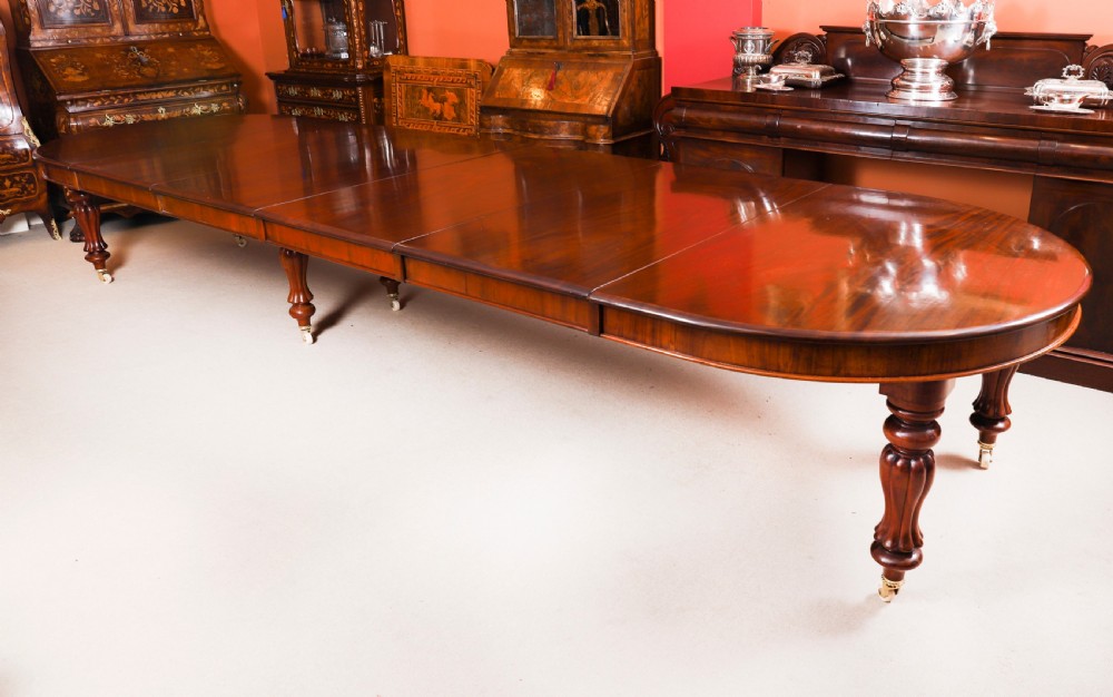 An extended 15ft George III Cuban flame mahogany dining table with turned reeded legs and brass castors.