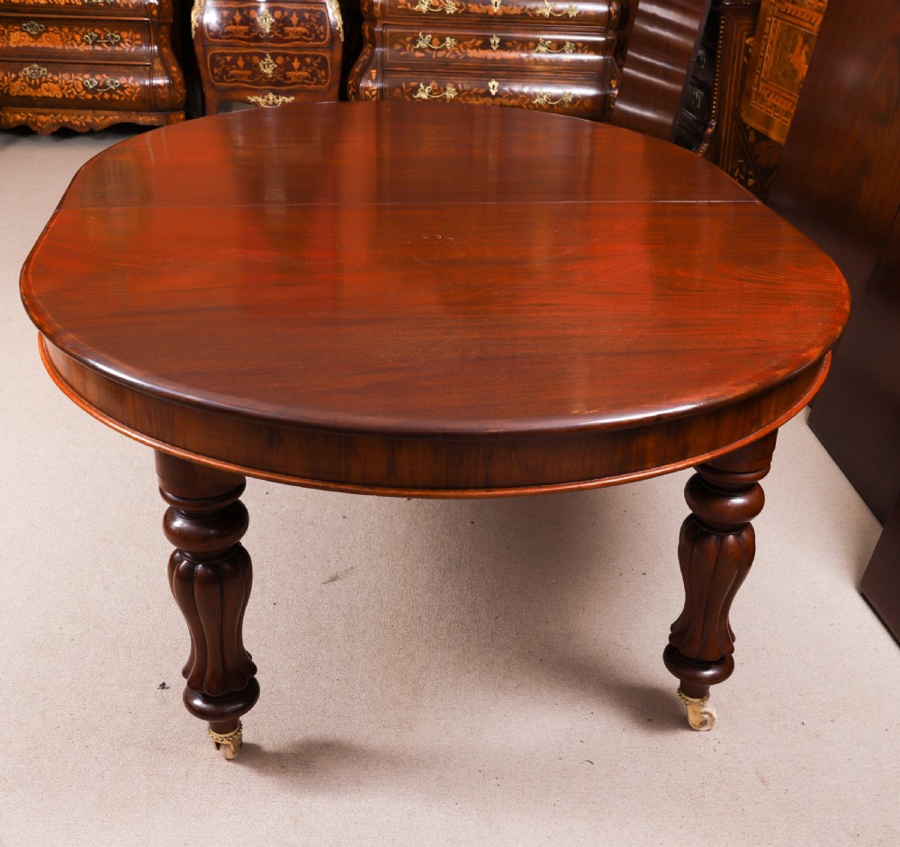 An extended 15ft George III Cuban flame mahogany dining table with turned reeded legs and brass castors. View XI