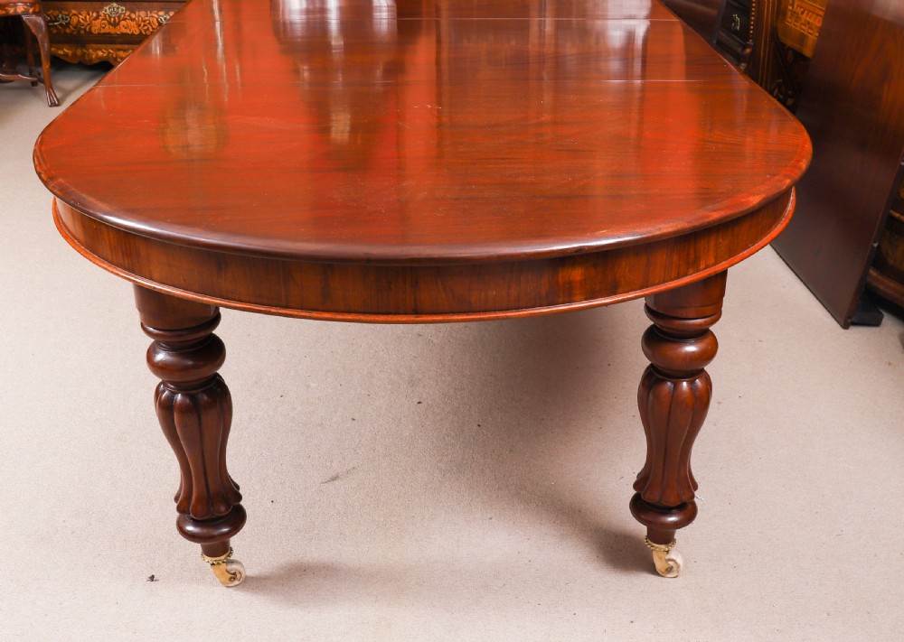 An extended 15ft George III Cuban flame mahogany dining table with turned reeded legs and brass castors. View XV