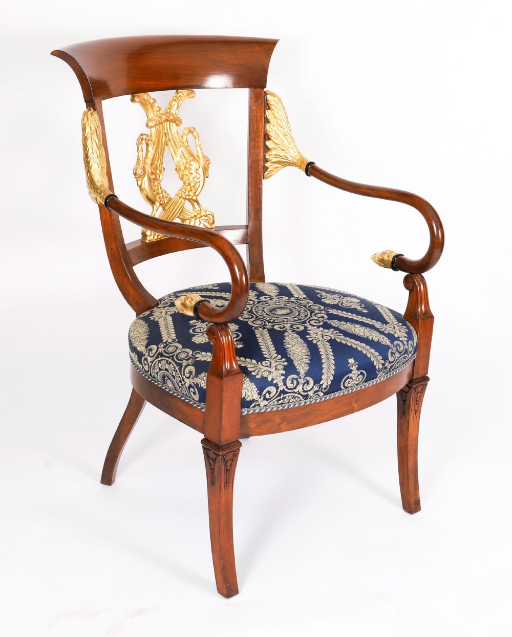 A pair of Italian Neoclassical armchairs featuring dark wood frames with giltwood swan carved back splats and blue patterned upholstered seats. View II