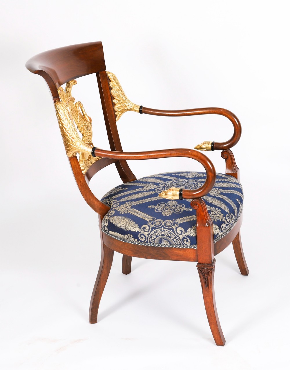 A pair of Italian Neoclassical armchairs featuring dark wood frames with giltwood swan carved back splats and blue patterned upholstered seats. View IV
