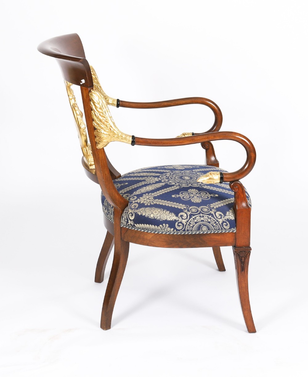 A pair of Italian Neoclassical armchairs featuring dark wood frames with giltwood swan carved back splats and blue patterned upholstered seats. View VI