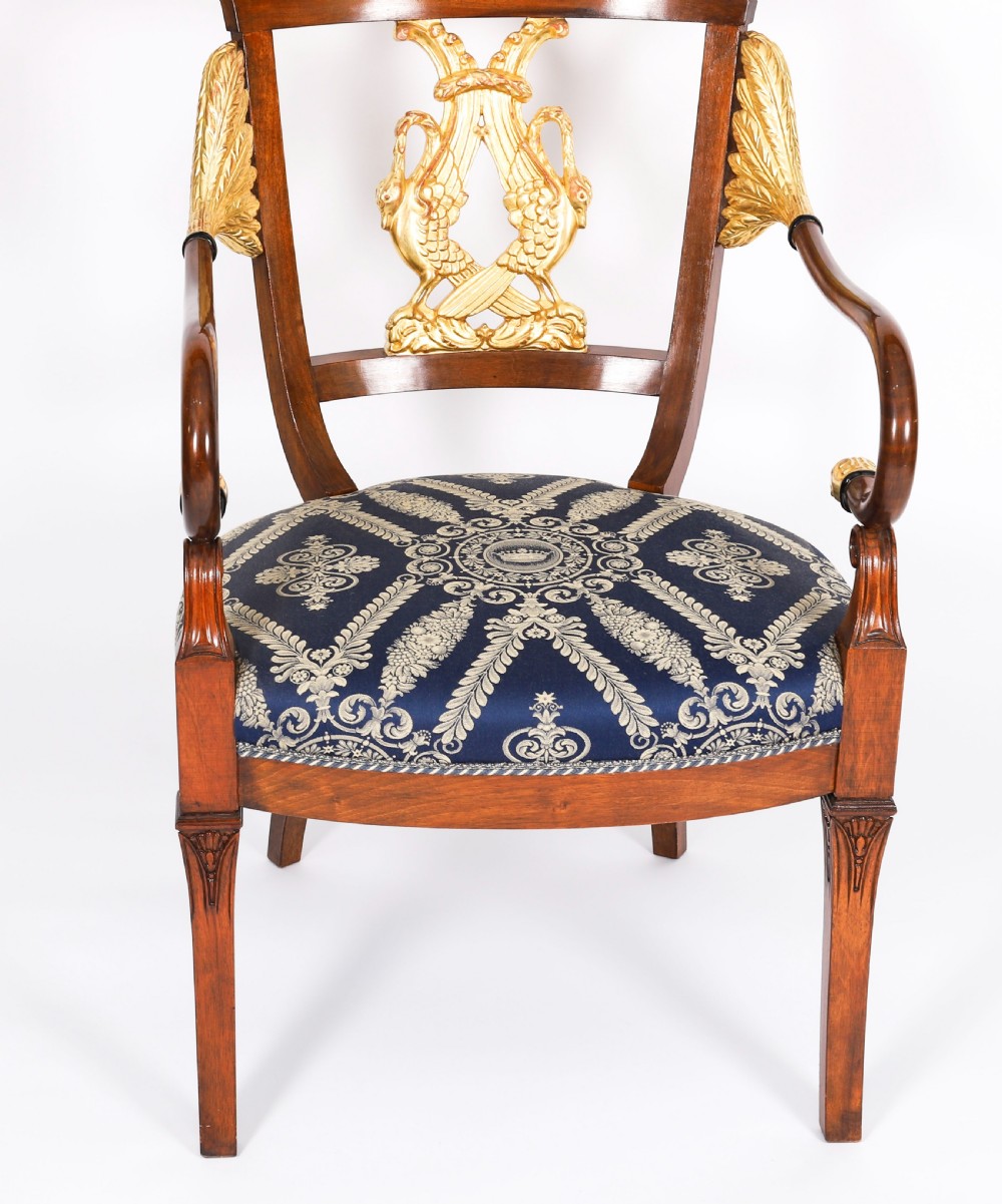 A pair of Italian Neoclassical armchairs featuring dark wood frames with giltwood swan carved back splats and blue patterned upholstered seats. View VIII