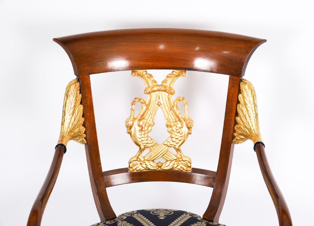 A pair of Italian Neoclassical armchairs featuring dark wood frames with giltwood swan carved back splats and blue patterned upholstered seats. View IX