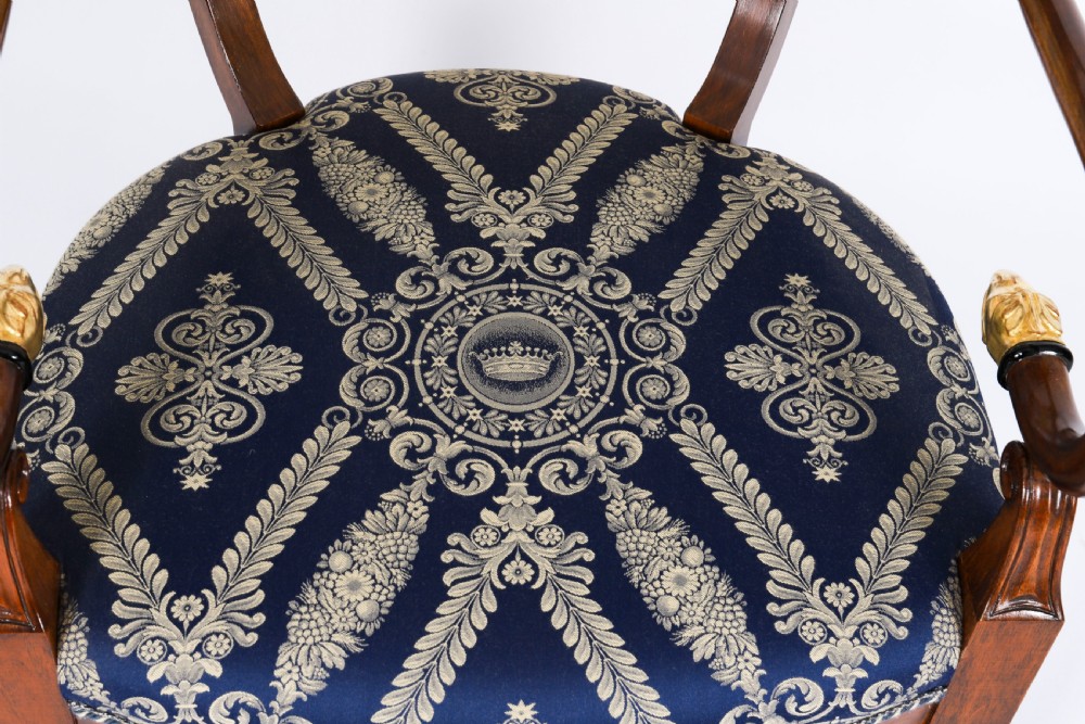 A pair of Italian Neoclassical armchairs featuring dark wood frames with giltwood swan carved back splats and blue patterned upholstered seats. View X