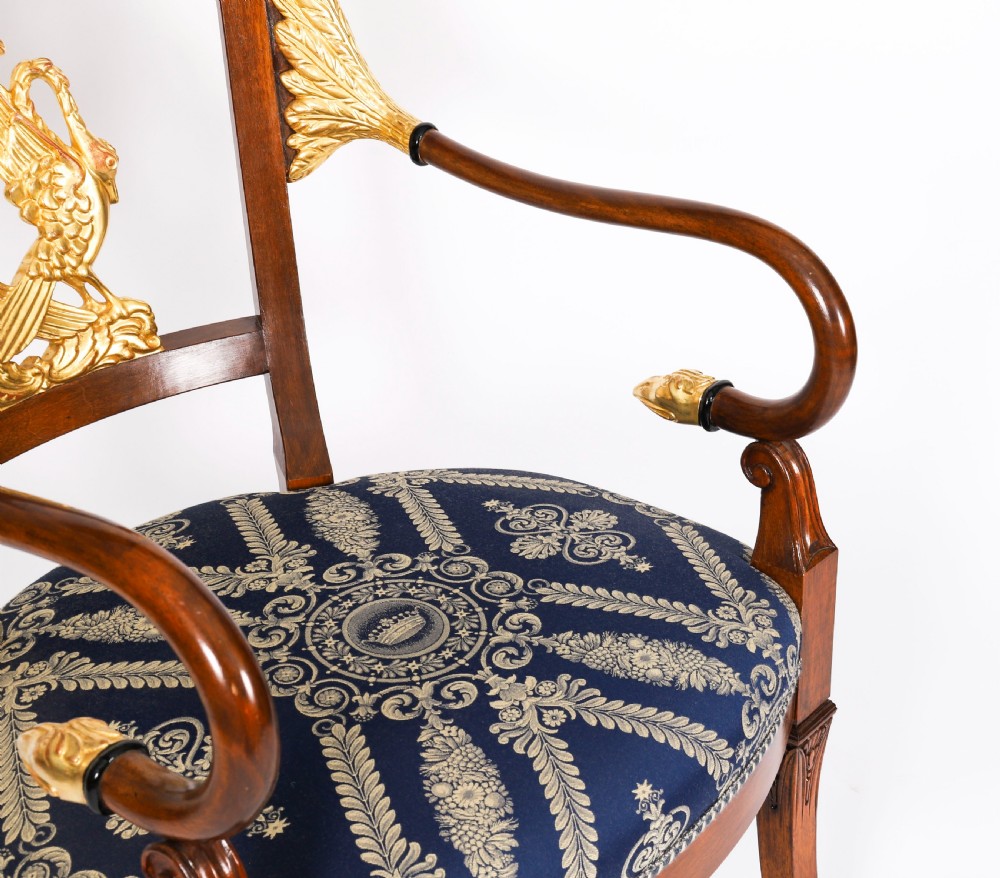 A pair of Italian Neoclassical armchairs featuring dark wood frames with giltwood swan carved back splats and blue patterned upholstered seats. View XII