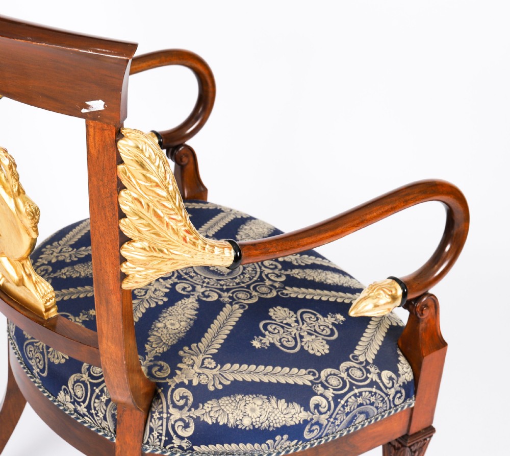 A pair of Italian Neoclassical armchairs featuring dark wood frames with giltwood swan carved back splats and blue patterned upholstered seats. View XIII