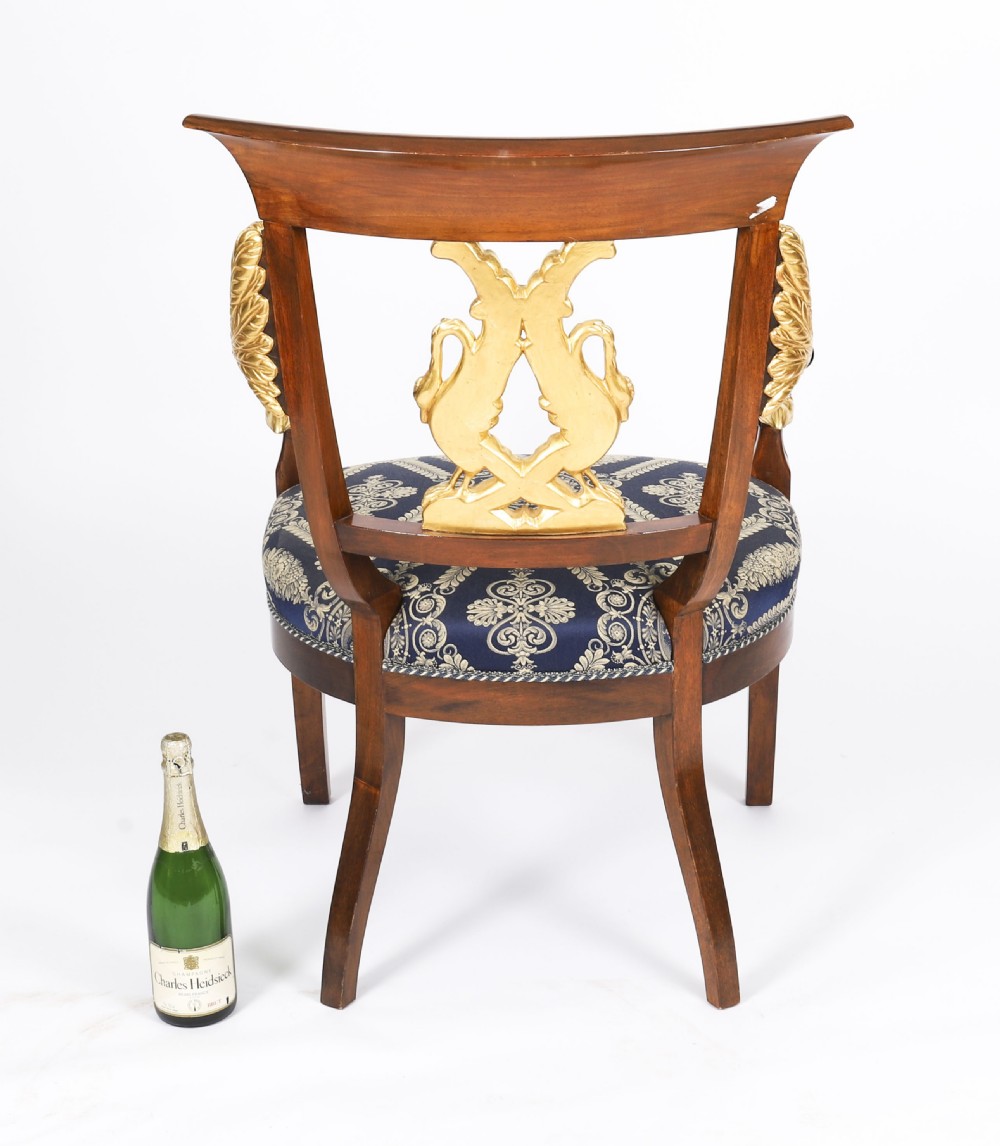 A pair of Italian Neoclassical armchairs featuring dark wood frames with giltwood swan carved back splats and blue patterned upholstered seats. View XVII