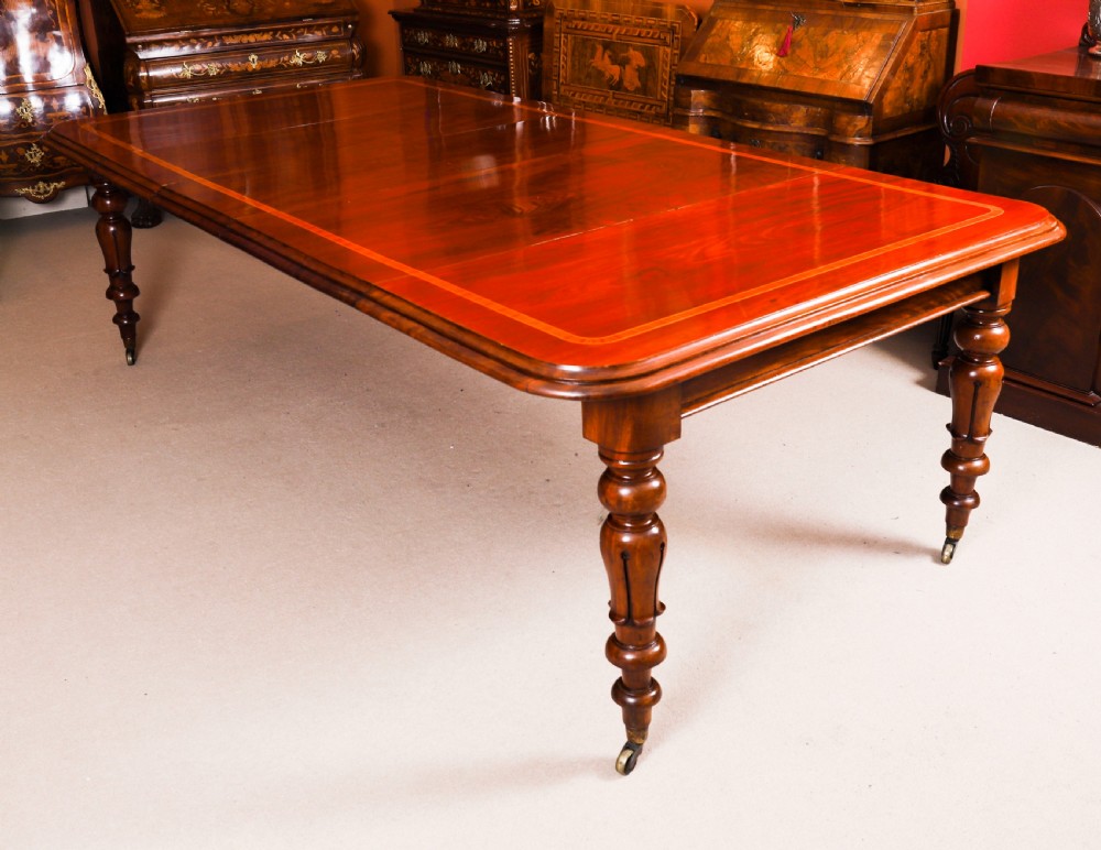 A 19th-century William IV flame mahogany extending dining table set on turned legs with brass castors.
