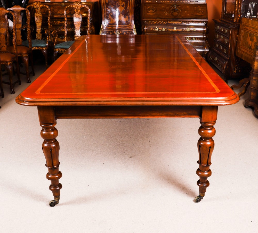 A 19th-century William IV flame mahogany extending dining table set on turned legs with brass castors. View II