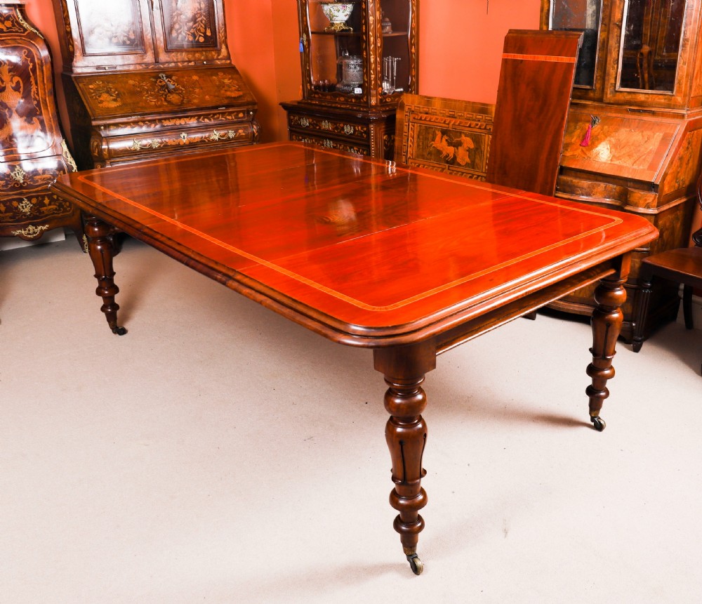 A 19th-century William IV flame mahogany extending dining table set on turned legs with brass castors. View VII