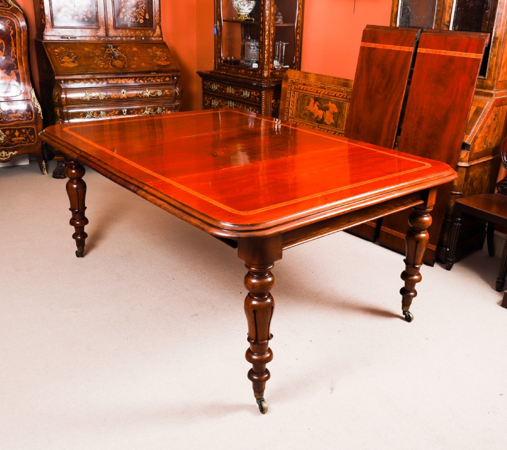 A 19th-century William IV flame mahogany extending dining table set on turned legs with brass castors. View VIII